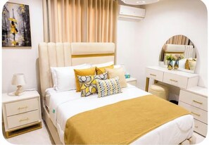 A hotel room with a bed, bedside tables, a dresser, and a mirror. - Apartment Charming 3-bedroom family apartment home in Santiago de los Caballeros (Santiago de los Caballeros)