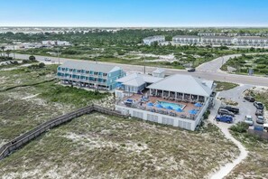 Un hôtel situé en bord de mer, doté d’une piscine, de plusieurs balcons et offrant une vue sur l’océan.