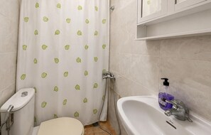 A bathroom with a toilet, shower, and sink. - Lovely apartment in Los Alcázares with WiFi (Los Alcázares)