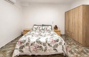 A bedroom with a bed, nightstands, a wardrobe, and a tiled floor. - Lovely apartment in Los Alcázares with WiFi (Los Alcázares)