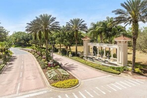 Een weg naar een toegangspoort met een bord waarop 'Emerald Island Resort' staat.