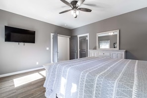 A bedroom with a bed, a ceiling fan, a TV, and a dresser. - Summit Trails Sanctuary: 3bdrm. Sleeps 8, Hot Tub, One level, Pool Table (Sevierville)