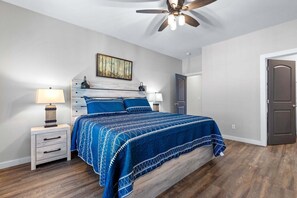 A bedroom with a bed, bedside tables, a ceiling fan, and a door. - Summit Trails Sanctuary: 3bdrm. Sleeps 8, Hot Tub, One level, Pool Table (Sevierville)