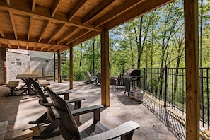 An outdoor patio with wooden benches, a grill, and a stone wall. - Summit Trails Sanctuary: 3bdrm. Sleeps 8, Hot Tub, One level, Pool Table (Sevierville)