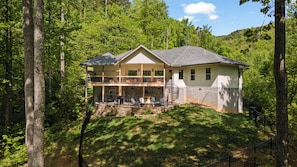A two-story house with a balcony, stone foundation, and a fire pit. - Summit Trails Sanctuary: 3bdrm. Sleeps 8, Hot Tub, One level, Pool Table (Sevierville)