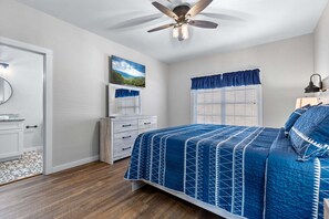A bedroom with a bed, a dresser, a ceiling fan, and a window with blinds. - Summit Trails Sanctuary: 3bdrm. Sleeps 8, Hot Tub, One level, Pool Table (Sevierville)