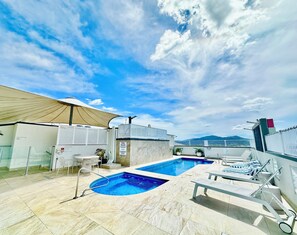 A rooftop pool area with a clear sky, a pool, lounge chairs, and a covered seating area. - Prime CBD Studio | City & Mountain Views (Cairns City)