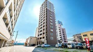 Un immeuble de grande hauteur doté de nombreux balcons et d’un parking situé à l’avant.