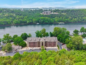 Ein mehrstöckiges Hotel mit Parkplatz und Blick auf einen Fluss.