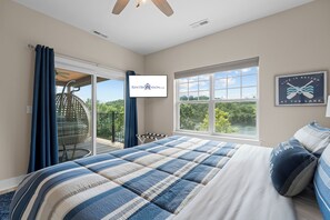 Ein Schlafzimmer mit einem großen Bett, Blick ins Freie und einem Schild an der Wand.
