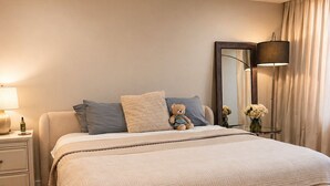 A bedroom with a bed, bedside tables, a lamp, a mirror, and a bench. - 2-bedroom apartment in fantastic Fort Lauderdale beach walking distance (Fort Lauderdale)