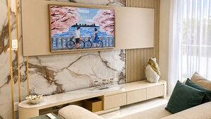 A modern living room with a marble wall, a mounted TV, a sofa, a side table, and a console table with decorative items. - 2-bedroom apartment in fantastic Fort Lauderdale beach walking distance (Fort Lauderdale)