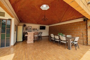 Un comedor amplio con pared de ladrillo, barra de piedra y techo con un diseño único de ladrillos.