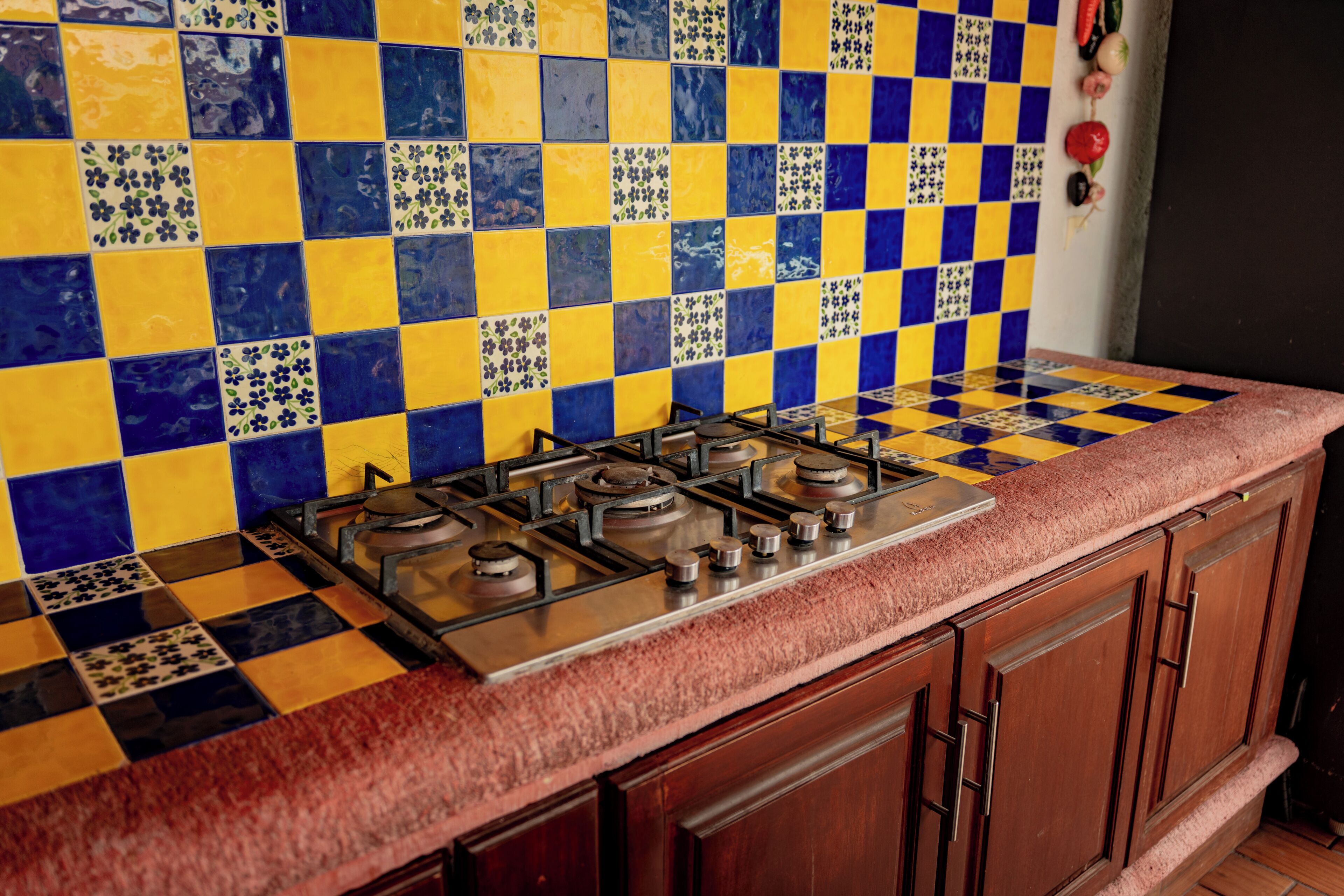 A kitchen with a checkered tile backsplash and a gas stove.