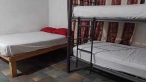 A bunk bed with a lower bunk and a single bed, both with white bedding. - HOSTAL PUNTACANA (Puerto Vallarta)