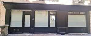 A building facade with three black-framed doors, each with a window above. - Apartment - 60 sqm - Montmartre - 6p (Paris)