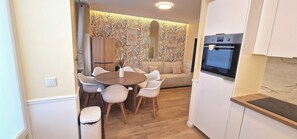 A compact kitchen with a dining area, a built-in oven, and a patterned wallpaper. - Apartment - 60 sqm - Montmartre - 6p (Paris)
