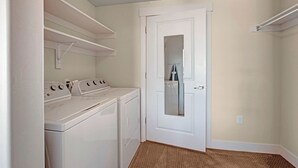 A laundry room with a white door, a washing machine, and a dryer. - Urban 1BR Downtown Delight (Salt Lake City)