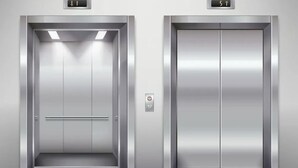 Two elevator doors with digital displays indicating floor numbers 1 and 5. - Urban 1BR Downtown Delight (Salt Lake City)