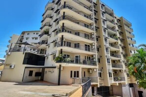 A multi-story residential building with balconies, air conditioning units, and a gated entrance. - City Room Minutes Walk to Waterfront & CDU Campus (Darwin City)
