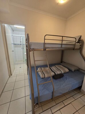 A bunk bed with a ladder, a single bed with a pillow, and a shower area. - City Room Minutes Walk to Waterfront & CDU Campus (Darwin City)