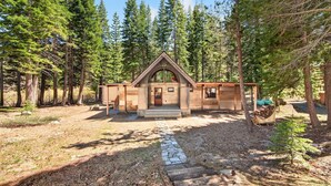 A rustic cabin with a pitched roof, a front porch, and a stone pathway leading to the entrance. - Marigold Cabin by Tahoe Getaways - 3BR in Alpine Meadows w/ Ski Shuttle! (Alpine Meadows)