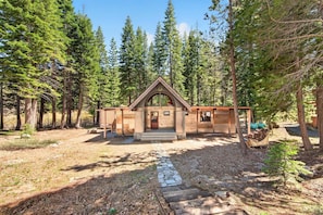 A rustic cabin with a pitched roof, a front porch, and a stone pathway leading to the entrance. - Marigold Cabin by Tahoe Getaways - 3BR in Alpine Meadows w/ Ski Shuttle! (Alpine Meadows)