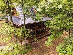 Eine Holzhütte mit einer Holzterrasse, umgeben von Bäumen.