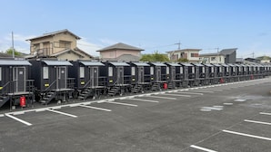 A row of train carriages parked in a lot with a clear sky. - HOTEL R9 The Yard Kurate (Kurate)