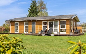 A wooden building with a flat roof, large windows, and a deck area with outdoor furniture. - Awesome home in Nordborg with WiFi (Nordborg)