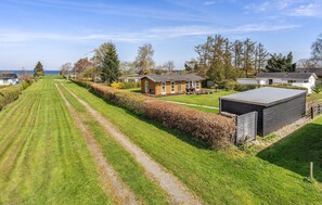 Ein Wohngebiet mit gepflegtem Rasen, einem Holzhaus und einem Schuppen.