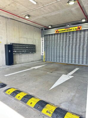 Eine Parkgarage mit maximaler Höhe von 2,8 Metern, Schild für gemeinsamer Zugang und Richtungspfeilen auf dem Boden.