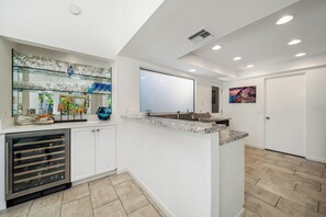 A modern kitchen with a wine rack, a built-in wine cooler, and a large mirror. - Beautiful modern 2-bedroom villa with gorgeous views in Ironwood CC Palm Desert (Palm Desert)