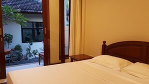 Une chambre d’hôtel avec un lit, une table de chevet et une vue sur l’extérieur.