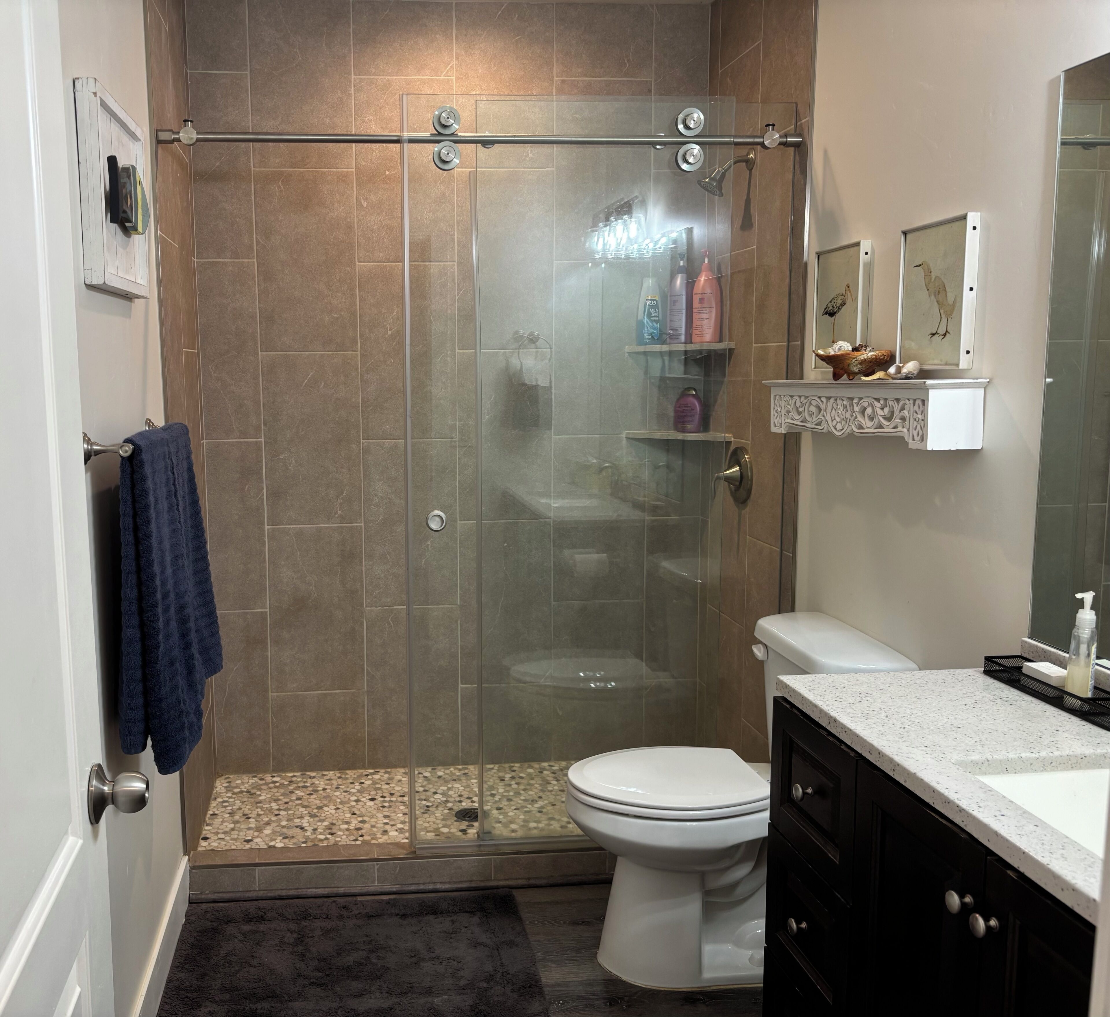 A modern bathroom with a glass-enclosed shower, a toilet, and a vanity with a sink.