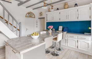 A kitchen with white cabinets, a marble countertop, and a blue backsplash. - Amazing home in Ploubazlanec with WiFi (Ploubazlanec)