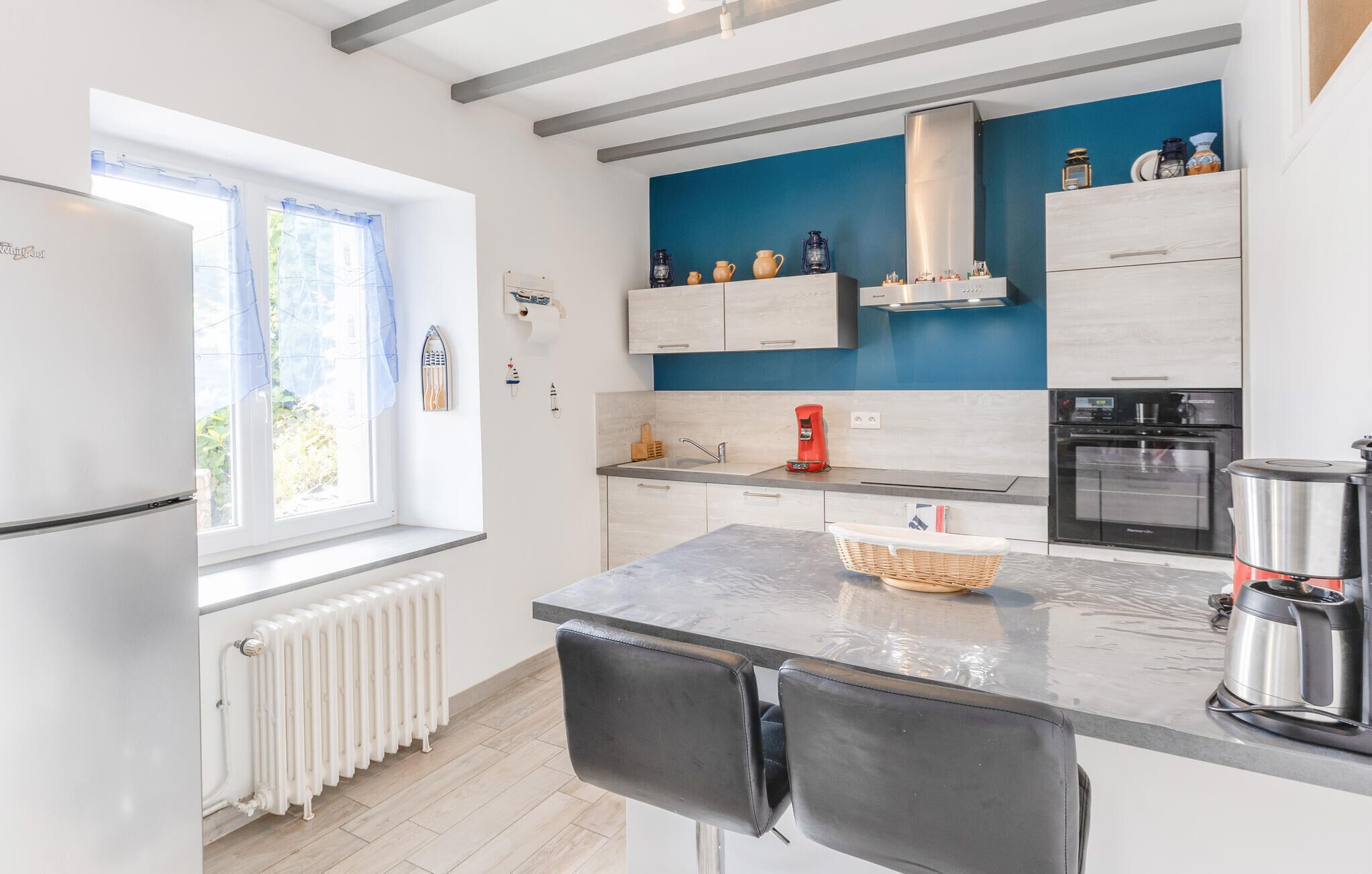 Une cuisine moderne équipée d’une cuisinière intégrée, d’une machine à café et d’un réfrigérateur.