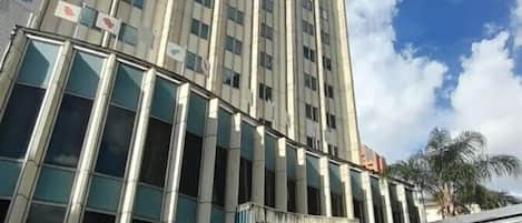 A tall hotel with a modern design, featuring a prominent entrance and a large glass facade.