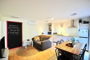 A compact living space with a kitchenette, a dining area, and a seating area with a sofa and a small table. - Comfy unit on a quiet low traffic street. Brand new kitchen, central in Melb S/E (Glen Waverley)