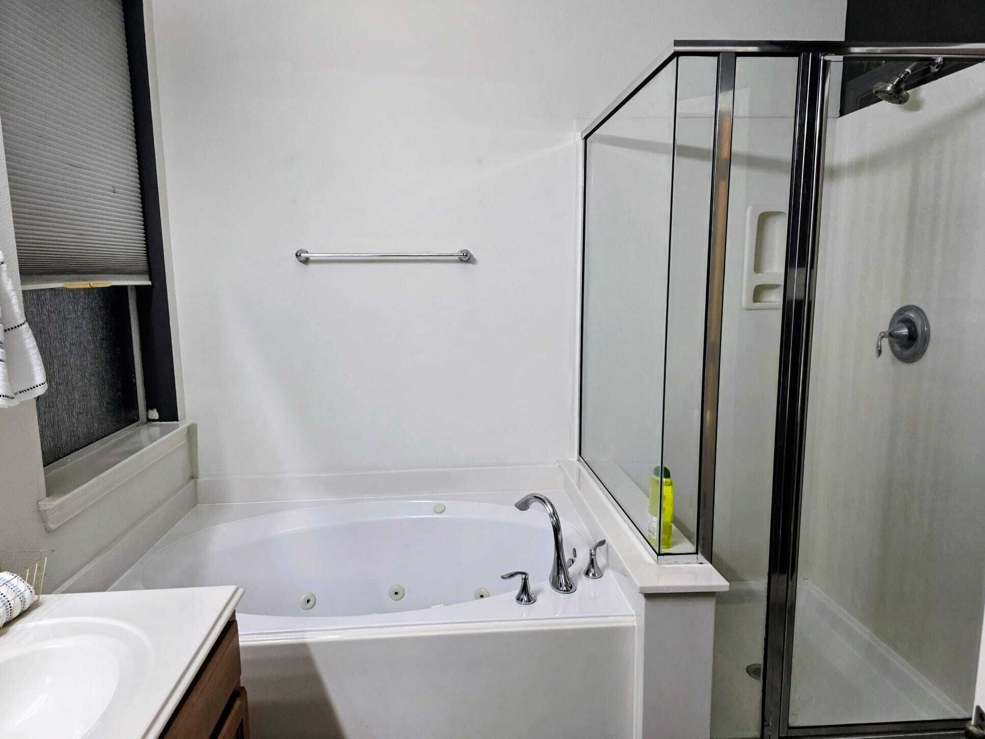 A bathroom with a bathtub, a shower enclosure, and a toilet.