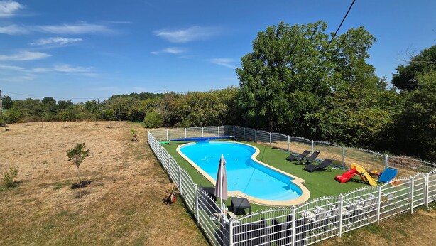 A fenced swimming pool with a slide and lounge chairs, surrounded by trees and a grassy area. - Nice home in Manthelan (Manthelan)