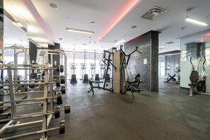 Ein Fitnessstudio mit verschiedenen Trainingsgeräten, darunter Kraftmaschinen und Kurzhanteln.
