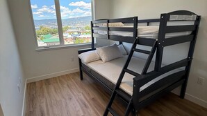Un letto a castello in una stanza con una finestra che si affaccia su un panorama urbano.