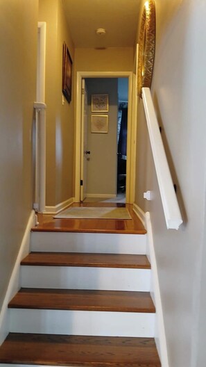 A narrow staircase with wooden steps and white handrails, leading to a door at the top. - Delightful 2-bedroom house with AC in charming Wenonah (Wenonah)