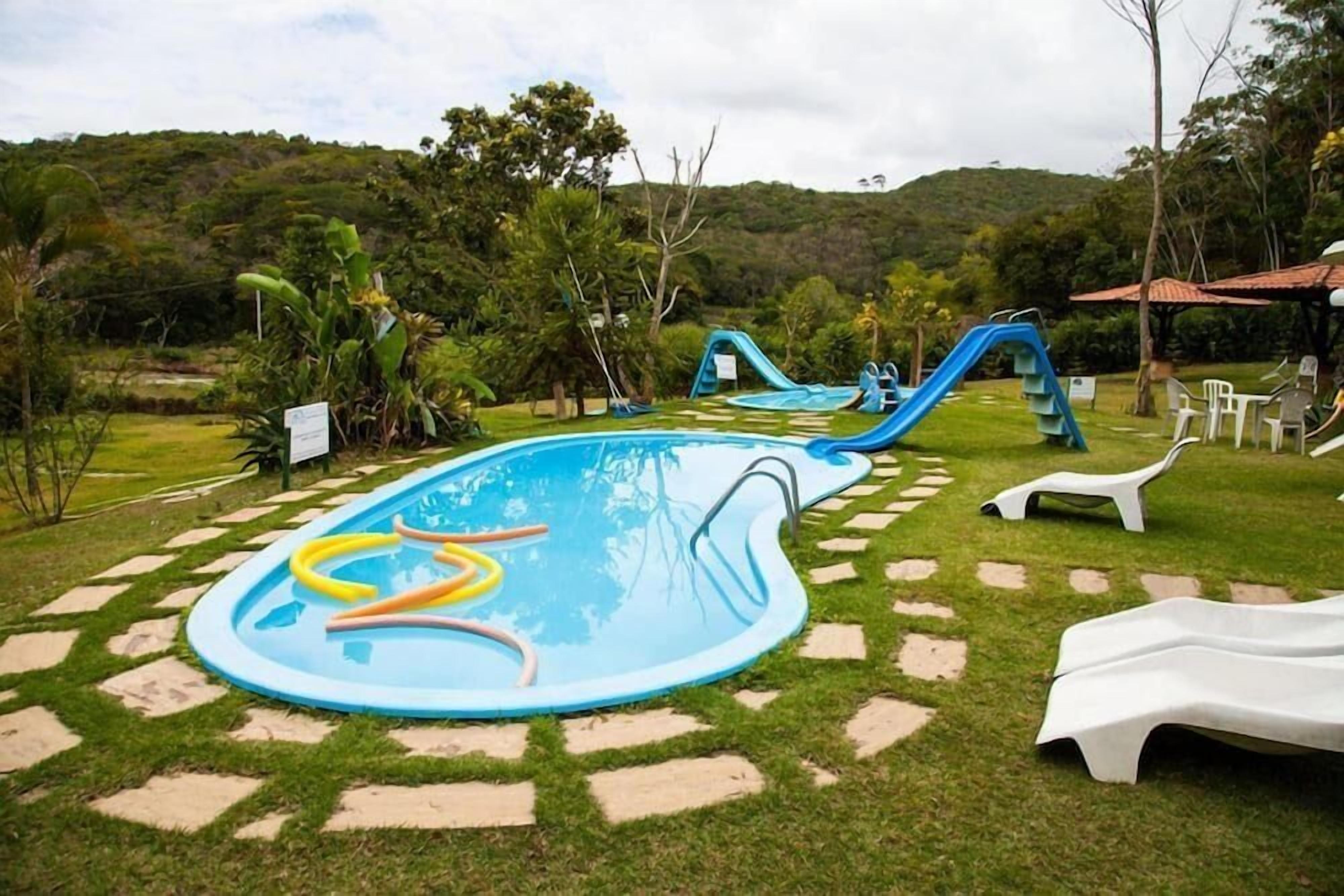 An outdoor swimming pool with slides and lounge chairs.