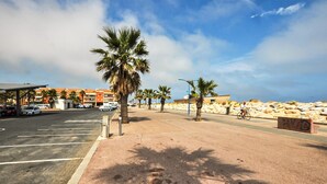 A parking area with marked spaces, a covered shelter, and a row of palm trees. - 5 bedroom cozy home in Sainte Marie La Mer Pl (Sainte Marie La Mer Pl)