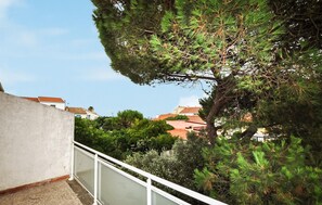 A balcony with a white railing overlooking a residential area with red-tiled roofs and dense greenery. - 5 bedroom cozy home in Sainte Marie La Mer Pl (Sainte Marie La Mer Pl)