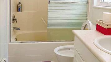 A bathroom with a glass-enclosed shower, a toilet, and a sink.