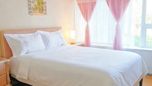 A bedroom with a large bed, a bedside table, a lamp, and a window with curtains. - Cozy Home in Vancouver (Vancouver)