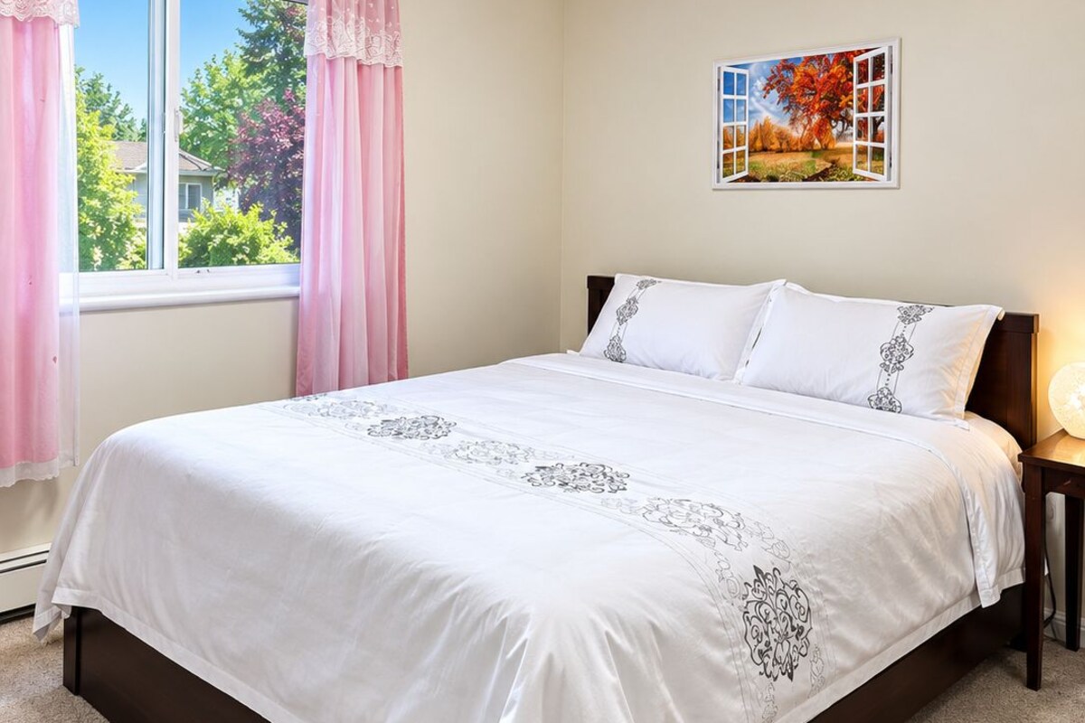 Un dormitorio con cama, ventana con cortinas, un cuadro en la pared y una lámpara en el techo.